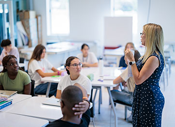 Photo of a woman teaching a class. Link to Life Stage Gift Planner Under Age 45 Situations.